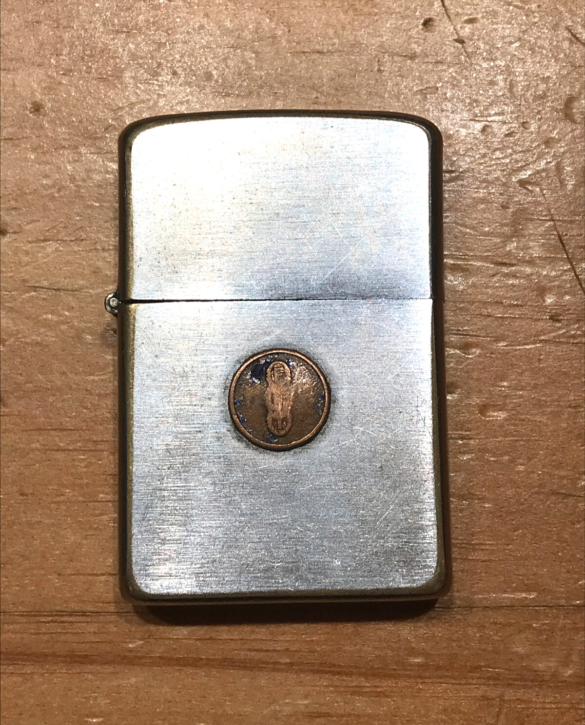 VINTAGE BRUSH CHROME ZIPPO LIGHTER WITH METAL EMBLEM ON THE FRONT PAT. 2517191